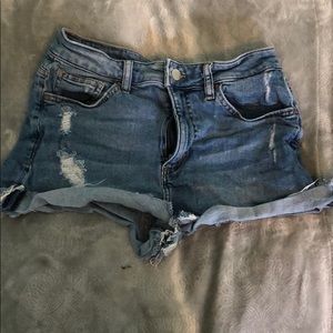 fringed and ripped blue jean shorts